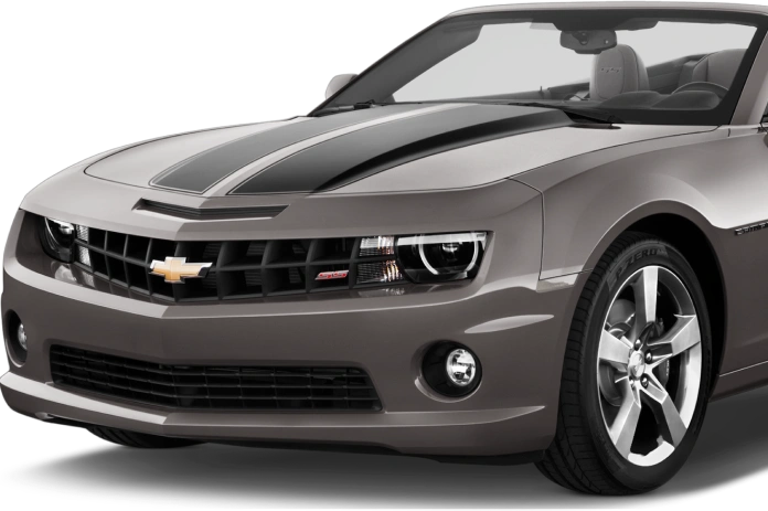 Front angle view of a gray Chevrolet Camaro convertible with a black racing stripe on the hood, aggressive headlights, and polished five-spoke wheels, highlighting its sporty and muscular design.