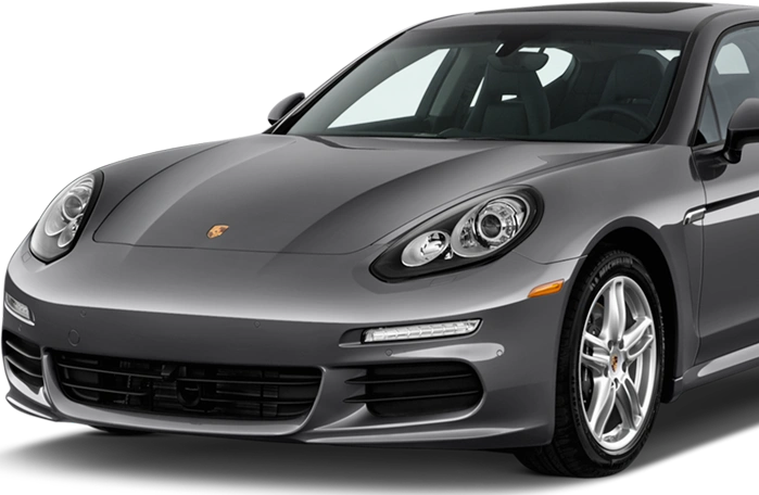 Front-side view of a sleek gray Porsche Panamera, showcasing its aerodynamic curves, signature headlights, and low-profile luxury styling.